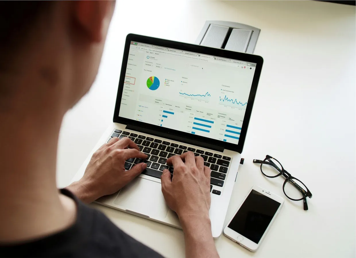 Reviewing call results on a laptop analytics dashboard with a phone on the desk