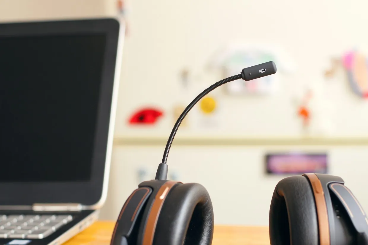 Headset resting beside an open laptop, ready for follow-up calls alongside email outreach