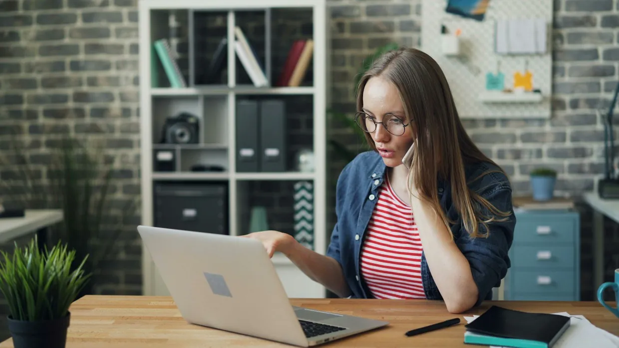 Assistant on the phone at her laptop, rearranging a meeting in a managed diary