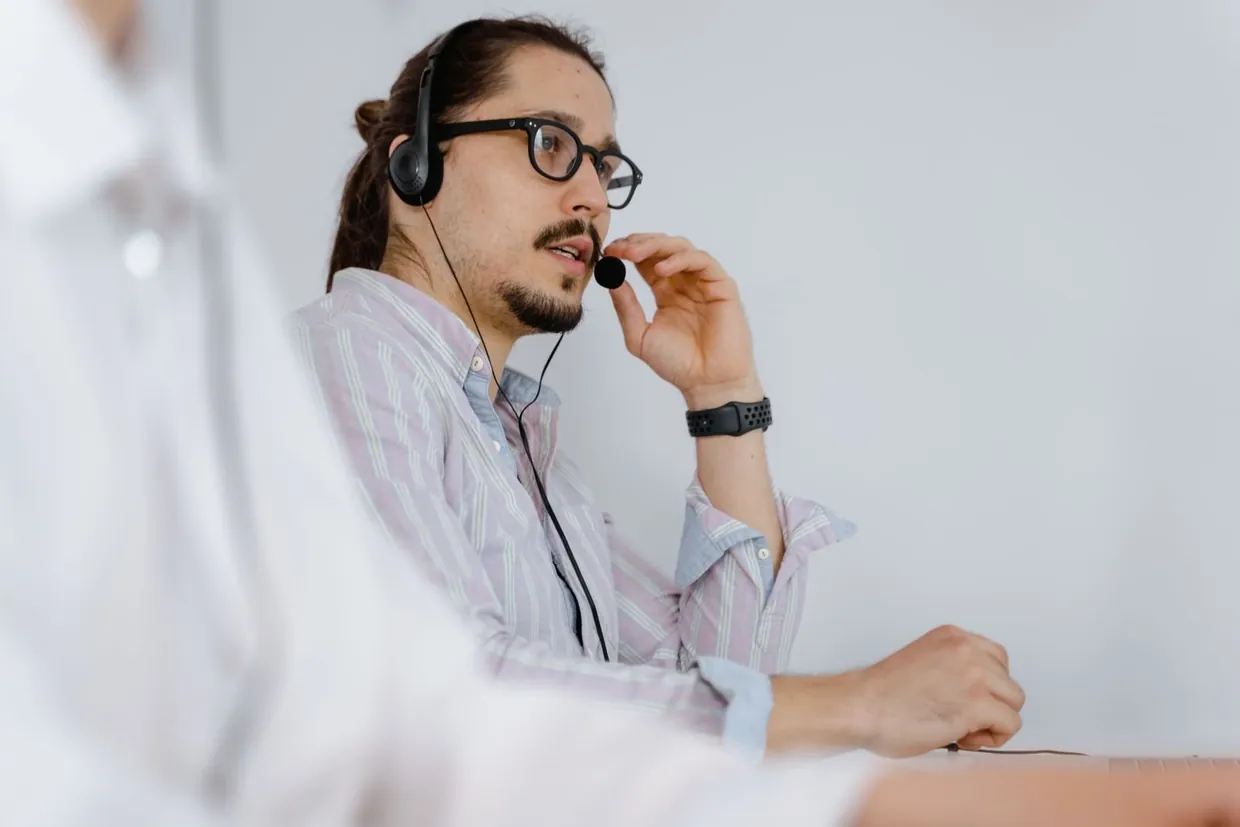 Support agent with a headset listening calmly while handling a customer complaint