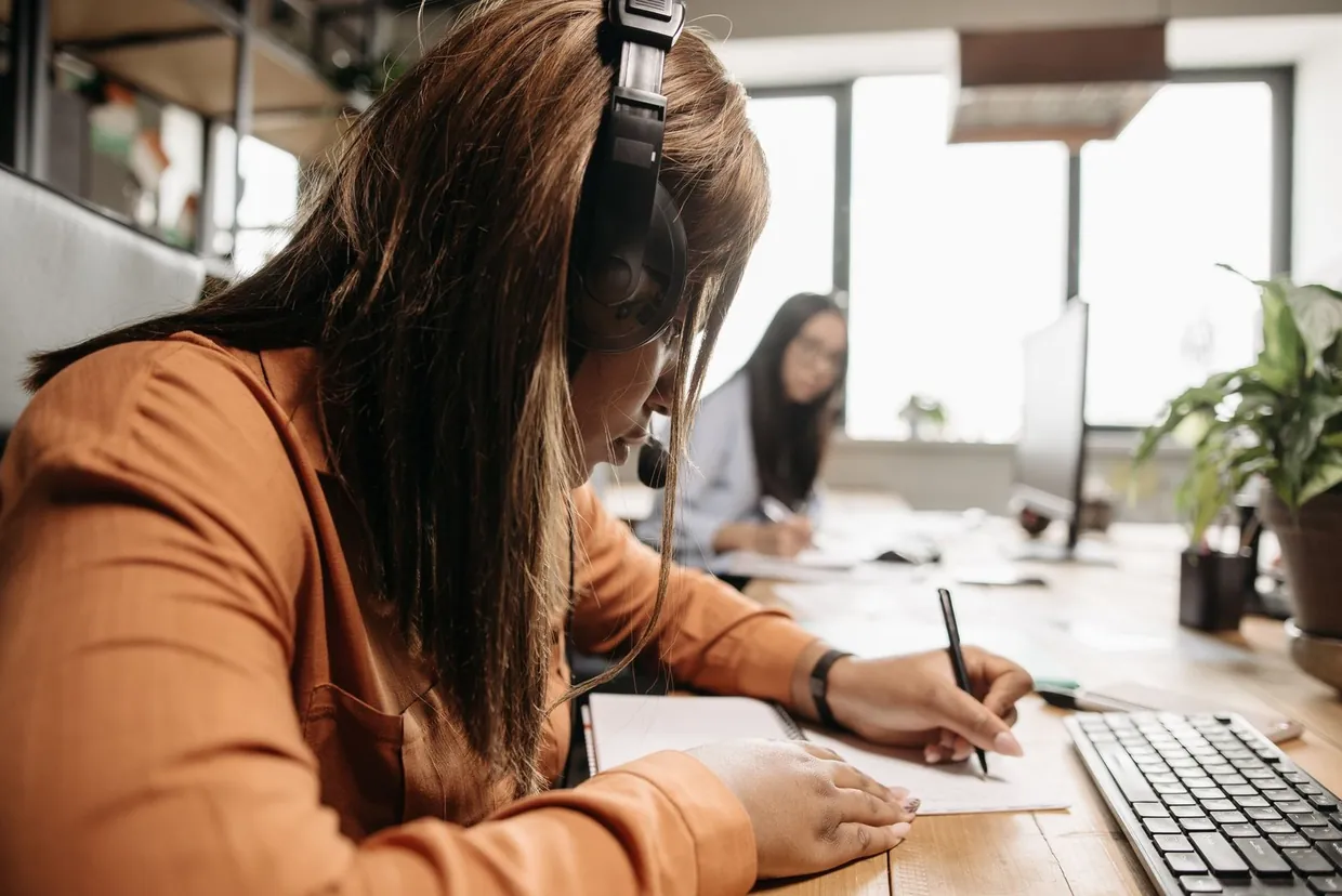 Call handler in a headset noting answers to provider questions during a legal call answering review