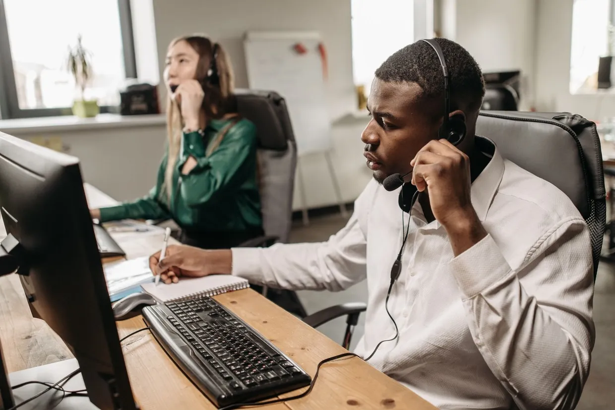 Virtual receptionist on a headset taking a caller's details and noting the booking