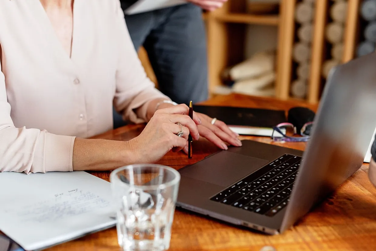 Virtual personal assistant working through a client's inbox and papers at a laptop