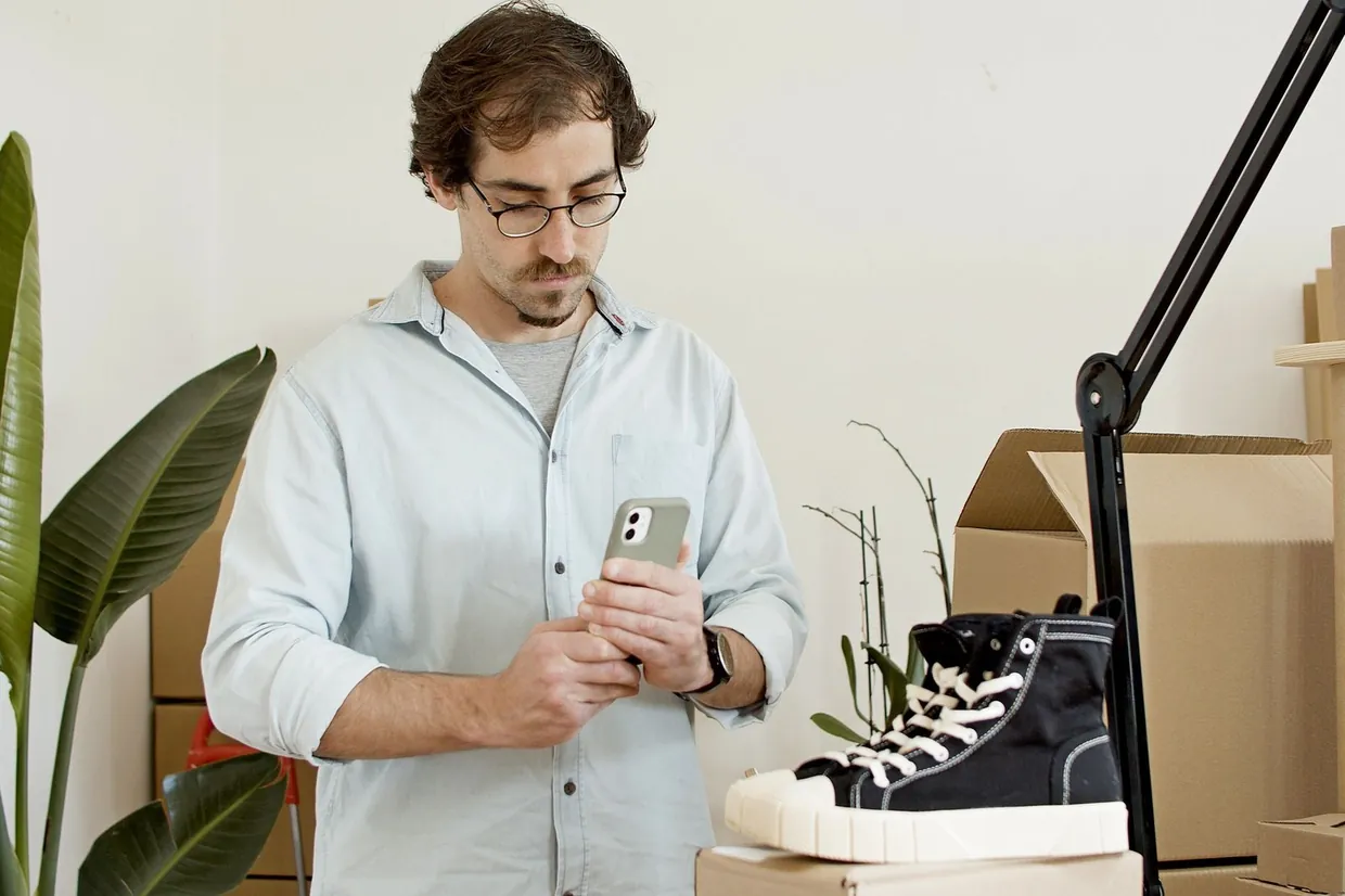 E-commerce assistant photographing a product with a phone for a new store listing